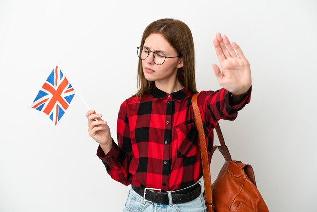 Jonge vrouw met een vlag van het Verenigd Koninkrijk geïsoleerd op een blauwe achtergrond die een stopgebaar maakt en teleurgesteld is?