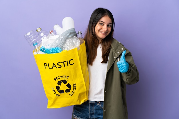 Jonge vrouw met een zak vol plastic flessen om te recyclen