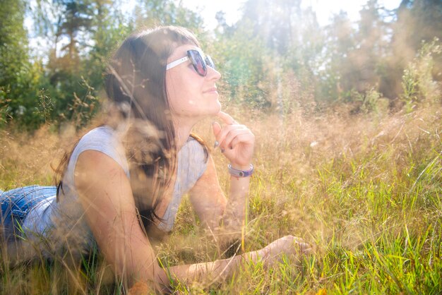 Foto jonge vrouw met een zonnebril op het veld