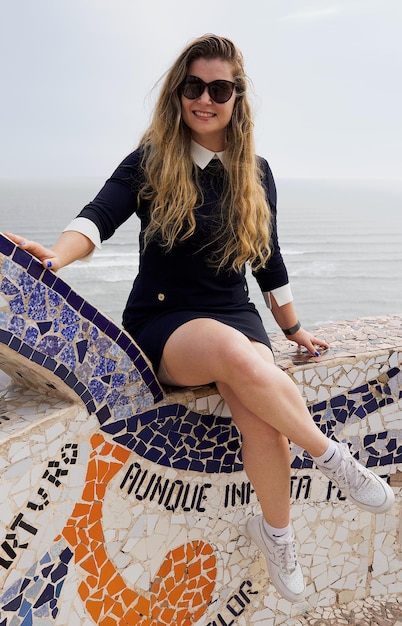 Foto jonge vrouw met een zonnebril tegen de zee.