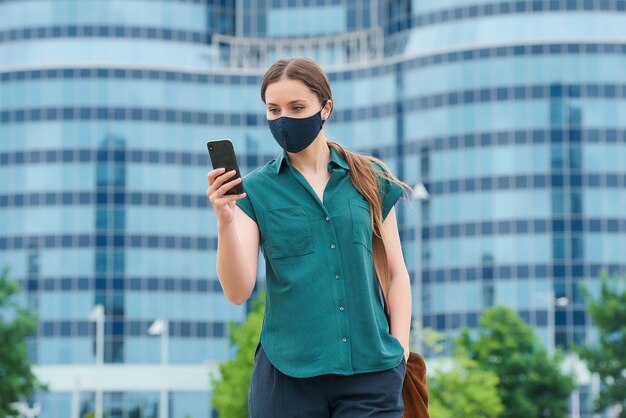 Jonge vrouw met een zwart gezichtsmasker in de stad