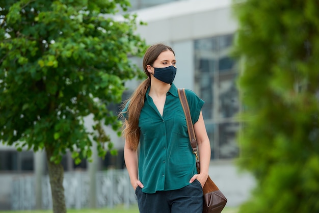 Jonge vrouw met een zwart gezichtsmasker in de stad