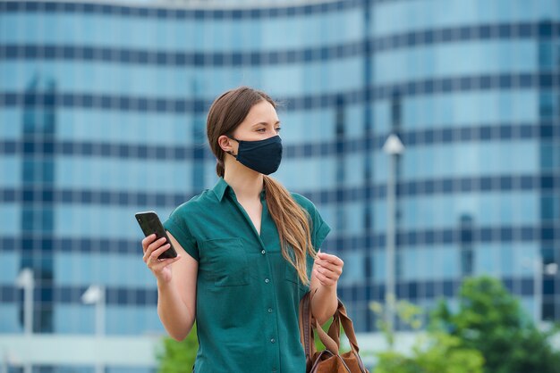 Jonge vrouw met een zwart gezichtsmasker in de stad