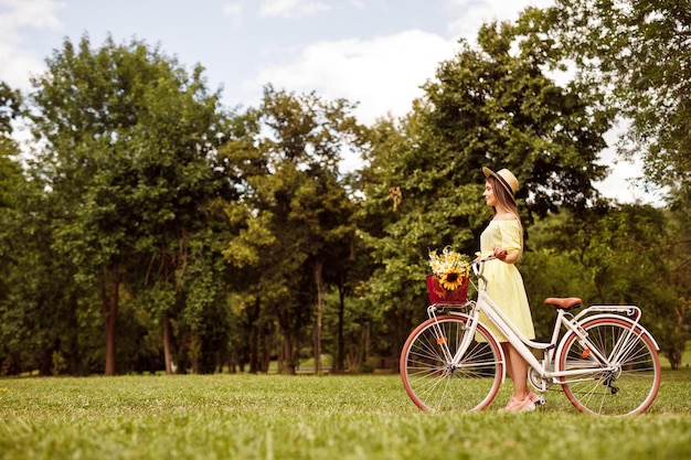 Jonge vrouw met fiets in weide