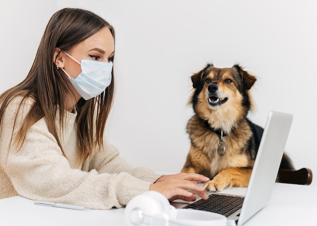 Jonge vrouw met gezichtsmasker die een videogesprek heeft