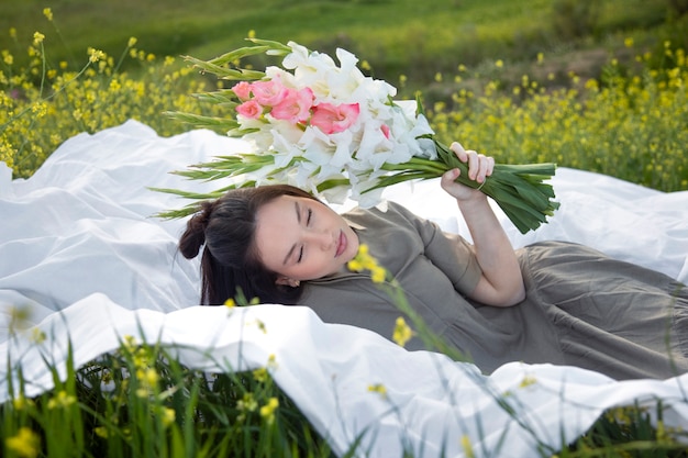 Jonge vrouw met gladiolen in de natuur