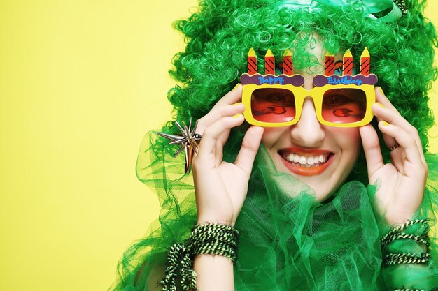 Jonge vrouw met groen haar en carnavalsbril