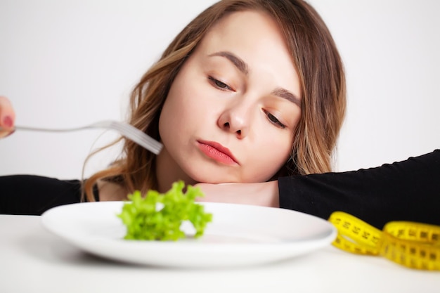 Jonge vrouw met groene broccoli, gezonde manier om af te vallen.