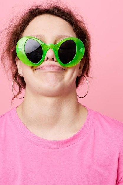 Foto jonge vrouw met groene glazen decoratie gebaar met zijn handen roze achtergrond