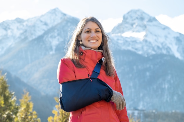 Foto jonge vrouw met haar beschadigde rechterarm na het snowboarden