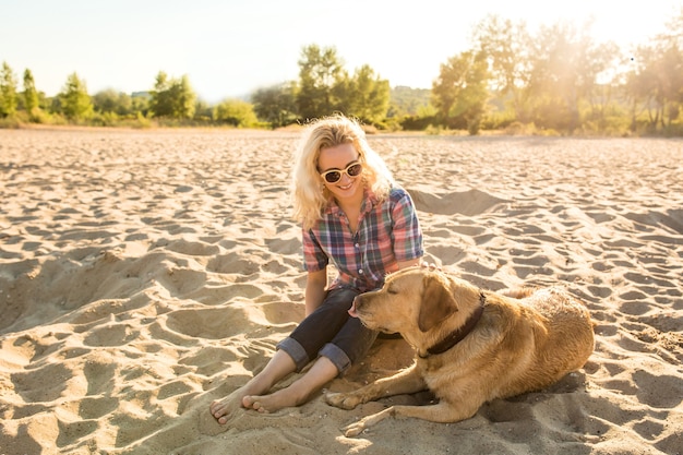 Jonge vrouw met haar hond op het strand