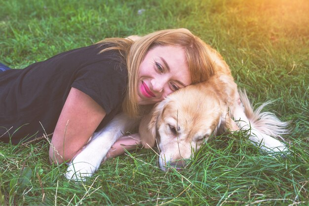 Jonge vrouw met haar hond retriever buitenshuis.