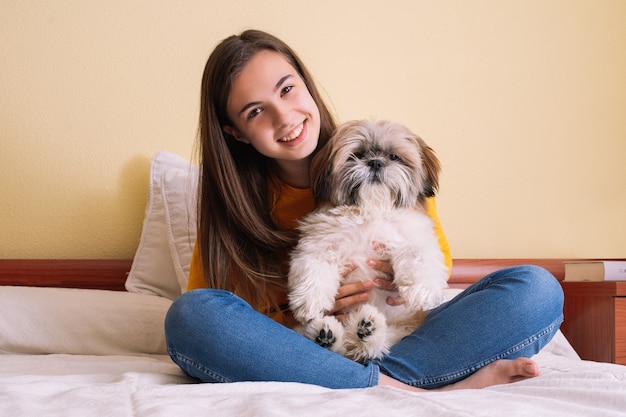 Jonge vrouw met haar hond spelen op het bed