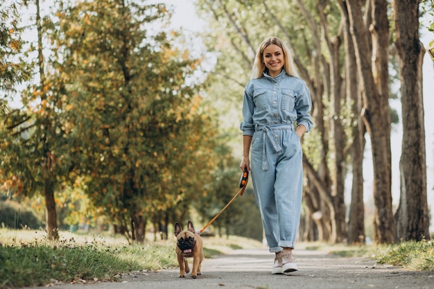 Jonge vrouw met haar huisdier Franse bulldog in park