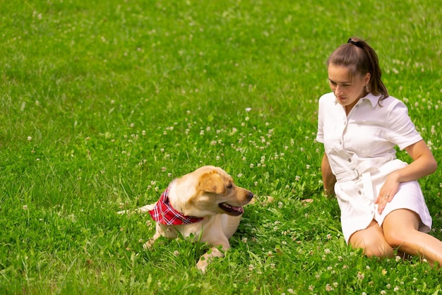 Jonge vrouw met haar schattige gele labrador buiten Mooi liefdesconcept voor gezelschapsdieren