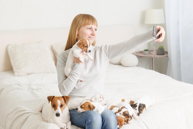 Jonge vrouw met haar schattige Jack Russell Terrier als stoel thuis wit huisdier