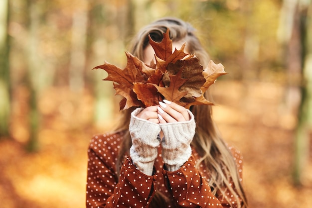 Jonge vrouw met herfstbladeren