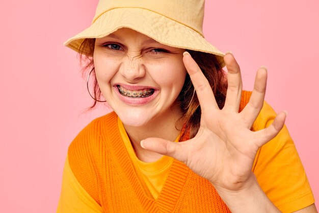 Foto jonge vrouw met hoed op een gele achtergrond