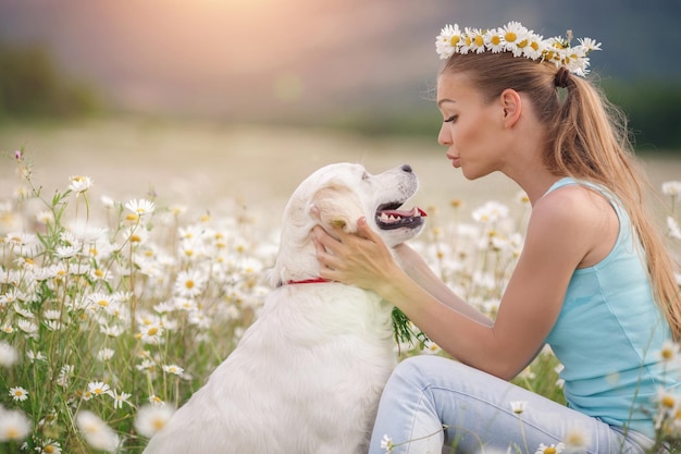 Jonge vrouw met hond in een kamilleveld