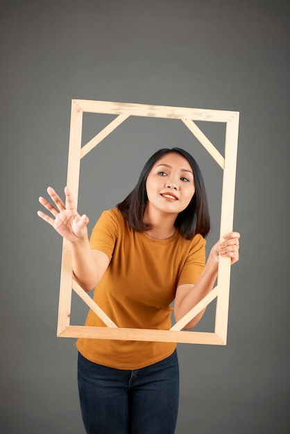 Jonge vrouw met houten afbeeldingsframe