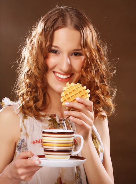 Jonge vrouw met koffie en koekjes