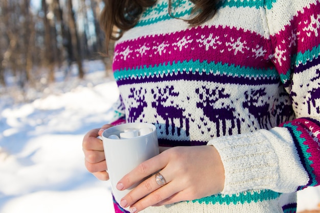 Jonge vrouw met kopje koffie met marshmallow