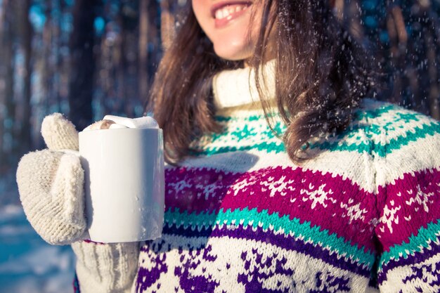 Jonge vrouw met kopje koffie met marshmallow