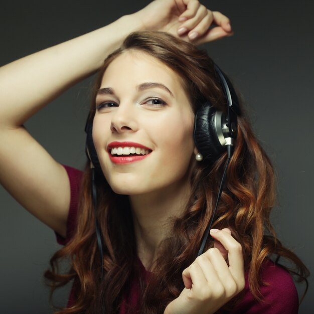 Jonge vrouw met koptelefoon die naar muziek luistert