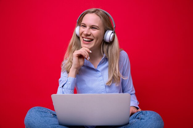 Jonge vrouw met koptelefoon typen op laptop