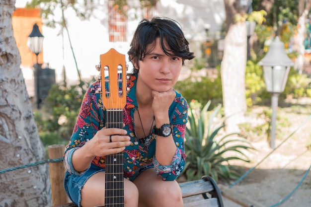 Jonge vrouw met kort haar met gitaar in het park