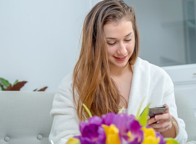 Jonge vrouw met lang haar met behulp van smartphone