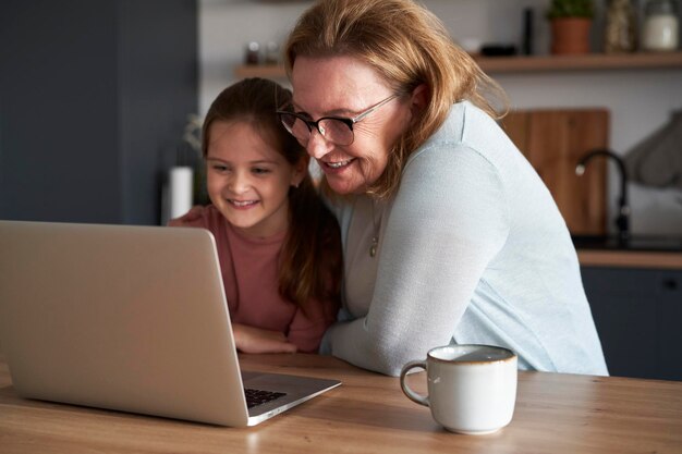 Foto jonge vrouw met laptop aan tafel