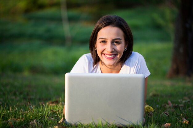 Jonge vrouw met laptop in park