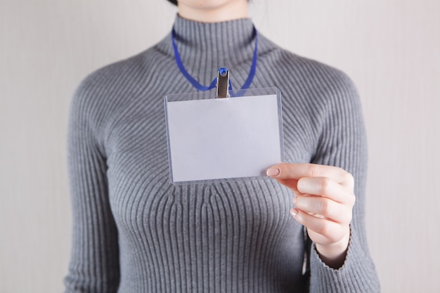 Jonge vrouw met lege badge op wit