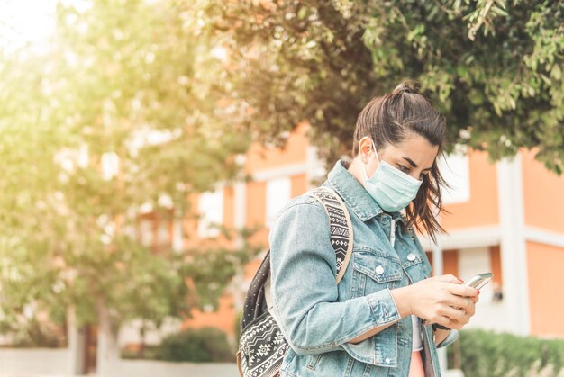 Jonge vrouw met mobiele telefoon buiten