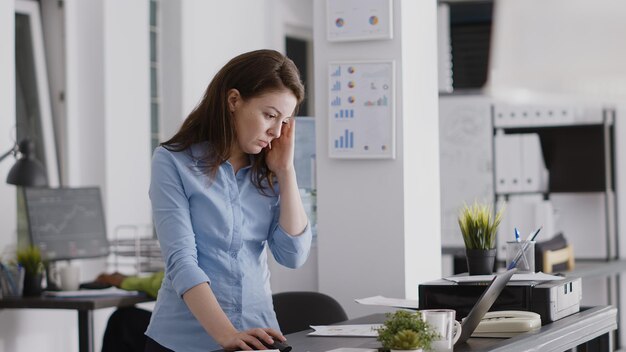 Foto jonge vrouw met mobiele telefoon op kantoor