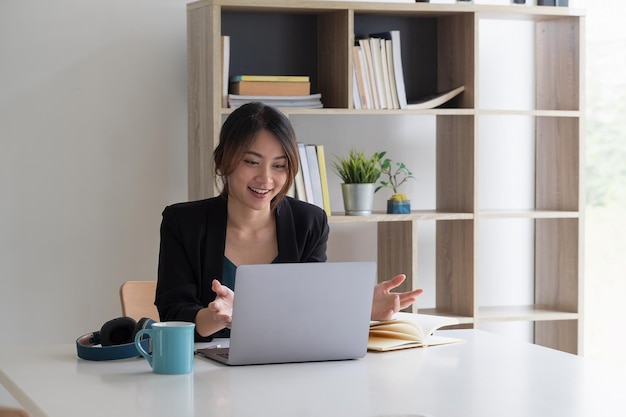 Jonge vrouw met mobiele telefoon terwijl ze op tafel zit