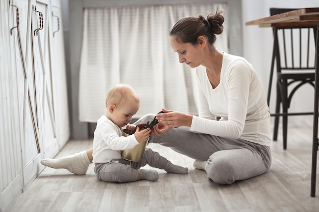 Jonge vrouw met mobiele telefoon terwijl ze thuis op bed zit