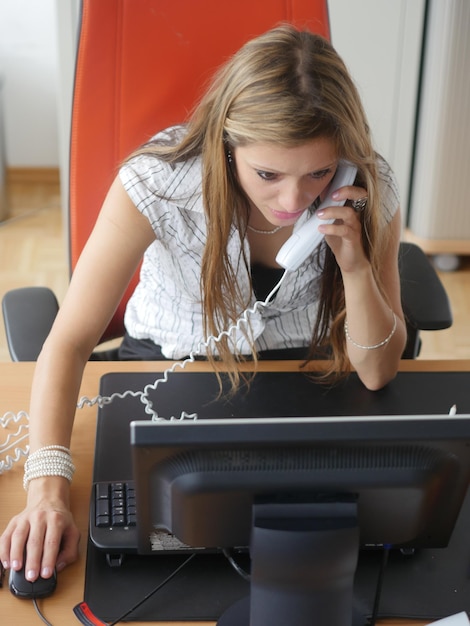 Foto jonge vrouw met mobiele telefoon terwijl ze thuis zit