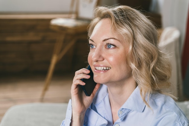 Jonge vrouw met mobiele telefoon thuis