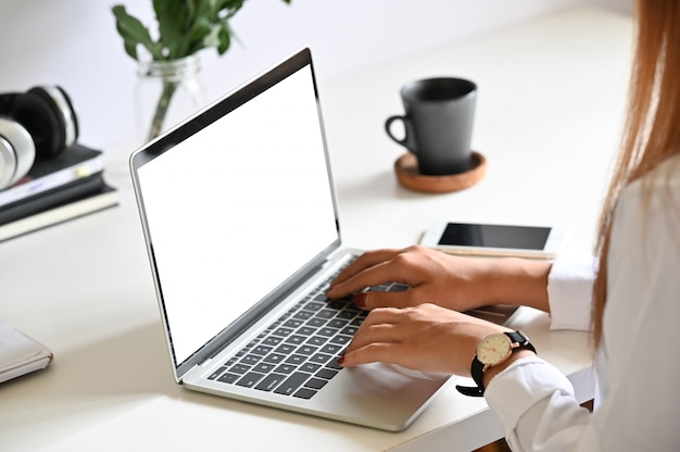 Foto jonge vrouw met mockup laptopcomputer op tafel