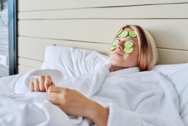 Foto jonge vrouw met natuurlijke komkommer gezichtsmasker huidverzorging op jonge leeftijd ontspanning schoonheid jeugd concept