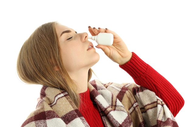 Jonge vrouw met neusspray geïsoleerd op witte achtergrond