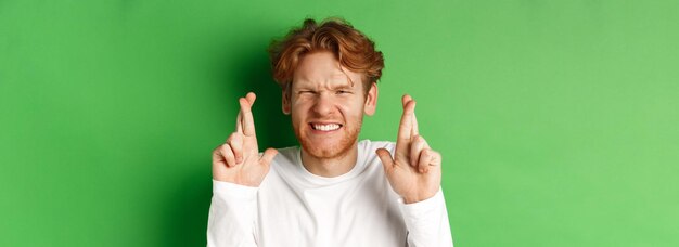 Foto jonge vrouw met opgeheven armen die tegen een blauwe achtergrond staat