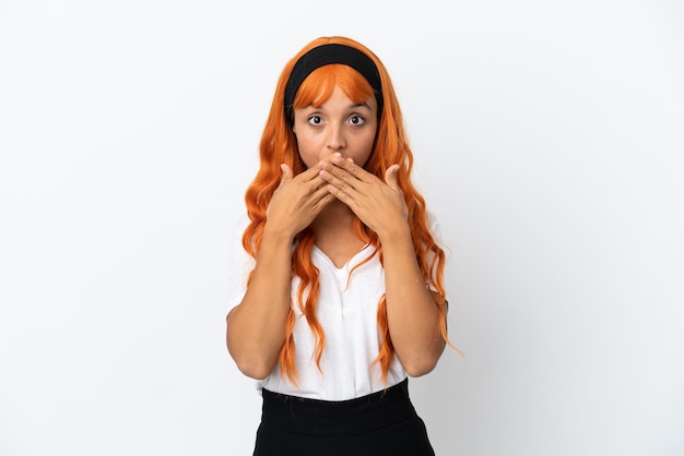 Jonge vrouw met oranje haar geïsoleerd op een witte achtergrond die de mond bedekt met handen