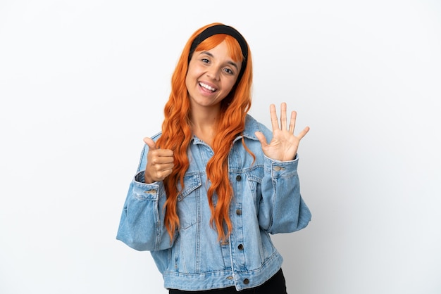 Jonge vrouw met oranje haar geïsoleerd op een witte achtergrond die zes met vingers telt