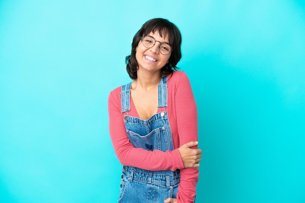 Jonge vrouw met overall geïsoleerde achtergrond lachen