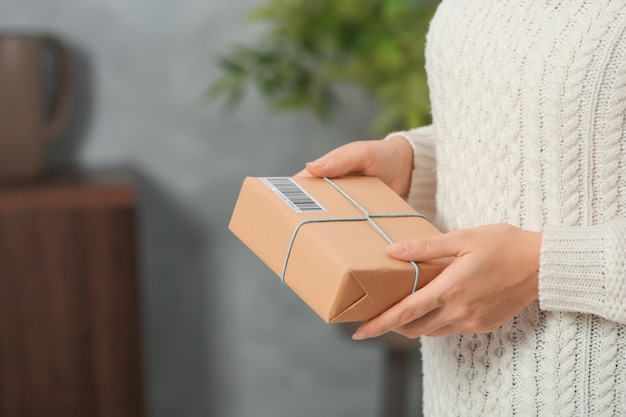 Foto jonge vrouw met pakket binnenshuis