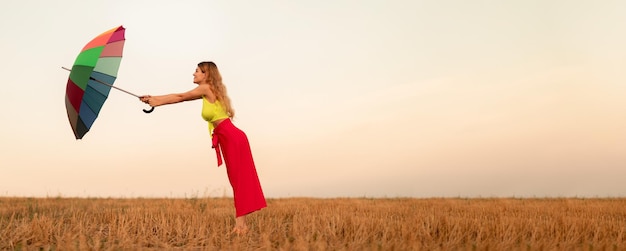 Jonge vrouw met paraplu die met wind worstelt