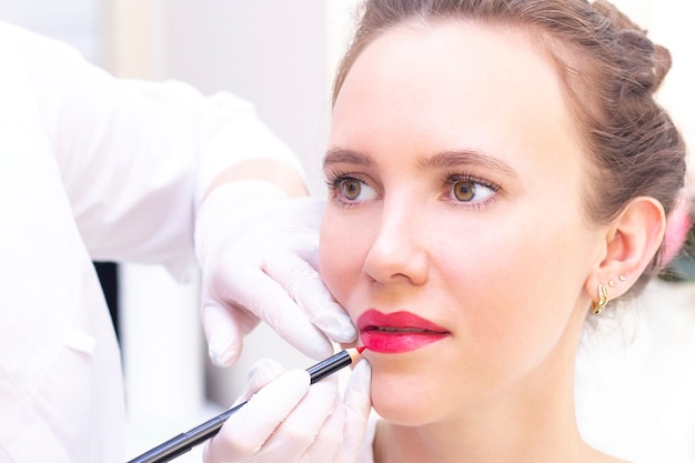 Jonge vrouw met permanente make-up op haar lippen in de salon van schoonheidsspecialisten